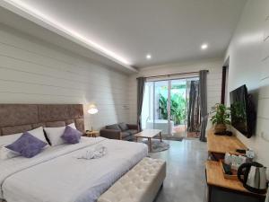 a bedroom with a large bed and a living room at NantraKiri in Ban Na Kham