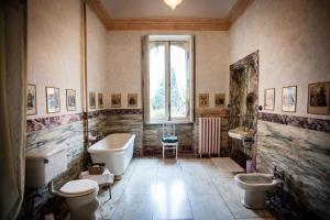 La salle de bains est pourvue de 2 toilettes, d'une baignoire et d'un lavabo. dans l'établissement Villa Cernigliaro Dimora Storica, à Sordevolo