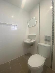 a white bathroom with a toilet and a sink at OYO 1135 Triple A Residence in Chiang Mai +48 photos