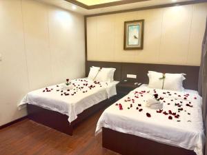 een kamer met twee bedden met rode rozen erop bij Hotel 007 in Sihanoukville
