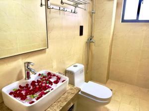 een badkamer met een wastafel met bloemen erin bij Hotel 007 in Sihanoukville +26 foto's