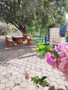 a park with a picnic table and pink flowers at Kids Friendly Seaside Apartments Grebaštica - Šibenik in Grebaštica