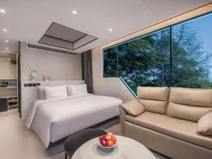 a bedroom with a bed and a large window at New Century Grand Hotel Xuzhou in Xuzhou +266 photos