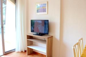 a television sitting on a wooden stand in a room at T2 Terrasse, Bormes Les Mimosas La Faviere, 5 Pers, 5 mn à pieds des plages et commerces in Bormes-les-Mimosas