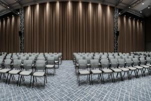 a conference room with chairs in front of a wall at Tauke Khan Plaza in Shymkent