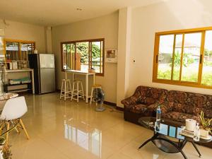 a living room with a couch and a table at Chiang Kham Ruk Khun Hotel in Chiang Kham
