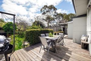 a patio with a table and chairs on a deck at Elva Garden Cottage in Margaret River Town