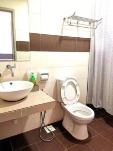 ein Badezimmer mit einer weißen Toilette und einem Waschbecken in der Unterkunft Palace Melaka Top 1 Waterpark Tickets with Unlimited Access by YGM in Malakka