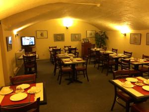 a dining room with tables and chairs and a television at Hotel Elysée in Lyon
