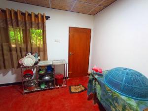 Habitación con cama, mesa y puerta en Sunrise Jungle Villa, en Mirissa