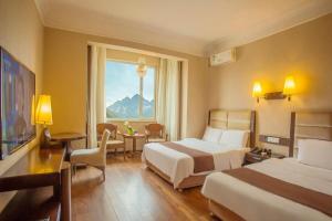 ein Hotelzimmer mit zwei Betten und einem Fenster in der Unterkunft Anshan Camilla Business Hotel in Anshan + 239 Fotos