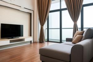 a living room with a couch and a flat screen tv at Riverson Soho Luxury Stay by Finest Homestay in Kota Kinabalu