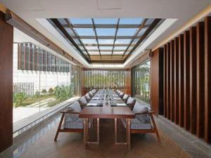 a long row of tables in a room with windows at Fliport Hotel Zhangzhou Yuanshan in Zhangzhou