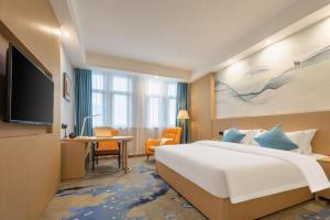 a hotel room with a large bed and a desk at Green Tree Eastern Hefei Dahua International Harbor Hotel in Hefei