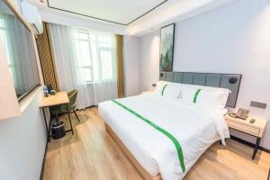 Ένα ή περισσότερα κρεβάτια σε δωμάτιο στο GreenTree Inn Qingdao Licang Shuyan Road Daweng Square Express Hotel +154 φωτογραφίες