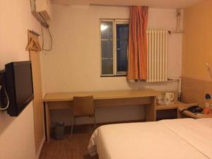 a bedroom with a desk and a bed and a window at 7 Days Inn Qingdao Shandong Road Zhenning Overpass Branch in Qingdao +200 photos