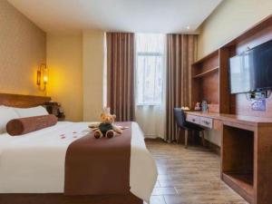 een hotelkamer met een teddybeer op een bed bij James Joyce Coffetel Bozhou Tangwang Road in Bozhou