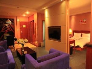 a hotel room with a bed and a living room at GreenTree Inn Lanzhou Yantan Road Express Hotel in Lanzhou