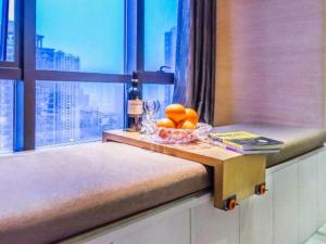 a bowl of oranges on a table in front of a window at Jiuwu Hotel Chongqing in Chongqing