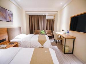 a hotel room with a bed and a desk at GreenTree Inn Hefei Chenghuangmiao San Xiao Kou Subway Station Hotel in Hefei