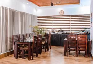 a dining room with a table and chairs and a clock at Evaara Resorts in Anachal