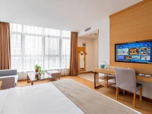 a hotel room with a bed and a desk and a television at GreenTree Inn Suzhou Changshu North Haiyu Road Changhui Square Express Hotel in Changshu