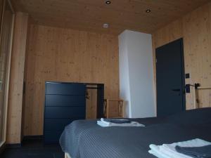 Un dormitorio con una cama y una pared de madera. en Ferienwohnung Urlaub mit Ausblick, en Bonndorf