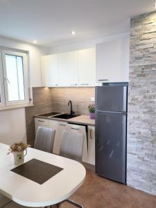 a kitchen with a white table and a refrigerator at Apartments Olive sea view in Mimice