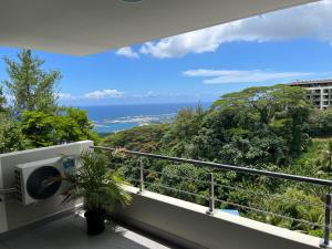 uma varanda com vista para o oceano em F2 Pamatai Nest - En hauteur, 10 min du centre ville - AC Wifi Piscine Em Faaa