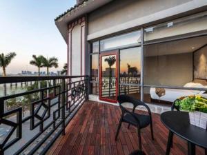 a balcony of a house with a table and chairs at Royal Bay Hotel in Towmoon