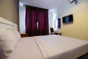 une chambre avec un lit blanc et une fenêtre dans l'établissement Wijaya Imperial Hotel, à Demangan