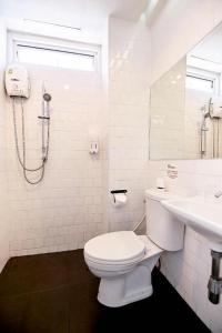 a white bathroom with a toilet and a sink at The rabbit's hole hostel in Bangkok +54 photos