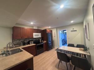 a kitchen with wooden cabinets and a table with chairs at Bella House in Surrey