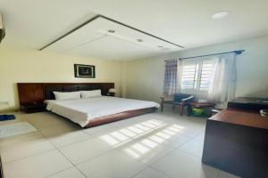 Binh Hung Hotel في مدينة هوشي منه: غرفة نوم بها سرير ومكتب ونافذة +138 صورة