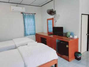 une chambre avec un lit et un bureau avec une télévision dans l'établissement Chill Beach Resort, à Pathiu
