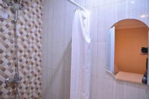 a shower with a white shower curtain and a mirror at W Home Express Tebet in Jakarta +147 photos