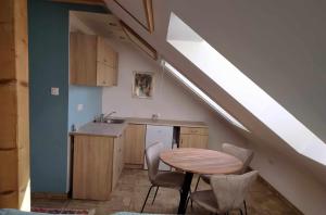 a kitchen with a table and chairs in a attic at Karmelita vendégház in Sopron
