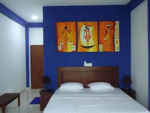 a bedroom with a blue wall with a bed at Bridge Hotel Negombo in Dagonna