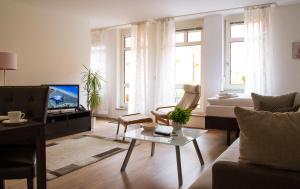 a living room with a couch and a tv at STADT-Hotel Lörrach GbR in Lörrach