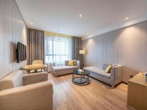a living room with two couches and a tv at Echarm Hotel Nanchang Hongcheng Wangfujing in Taohua