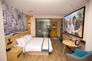 a hotel room with a large bed and a tv at City Comfort Inn Guigang Tangren Street in Guigang +198 photos
