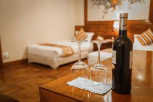 una bottiglia di vino e due bicchieri di vino su un tavolo di Grand Norling Hotel's Resort a Baudhatinchule