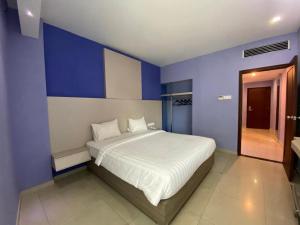 ein Schlafzimmer mit einem großen Bett mit blauen Wänden in der Unterkunft Kharisma Hotel in Madiun + 171 Fotos