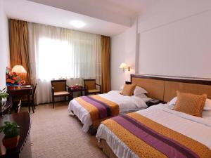 a hotel room with two beds and a desk at Baodao Exhibition Center Hotel in Wuyishan +97 photos