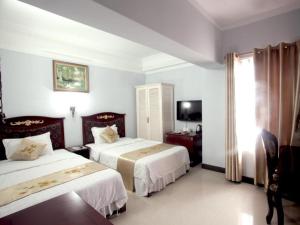 une chambre d'hôtel avec deux lits et une télévision dans l'établissement Classic Hoang Long Hotel, à Hai Phong 88 autres photos
