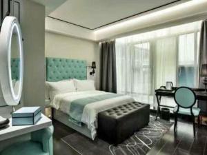 a bedroom with a bed and a desk and a mirror at Xana Hotelle XiAn Gig Wild Goose Pagoda Branch in Xi'an +267 photos