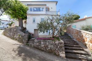 una casa con una pared de piedra y escaleras delante en Apartments & Rooms Nada, en Brseč