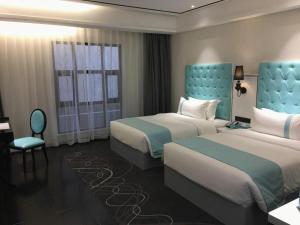 une chambre d'hôtel avec deux lits et une chaise dans l'établissement Xana Hotelle XiAn Gig Wild Goose Pagoda Branch, à Xi'an 224 autres photos
