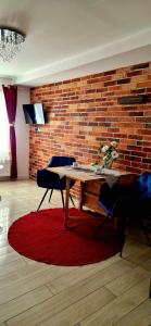 jadalnia ze stołem i ścianą z cegły w obiekcie Apartamenty Orchidea Łeba w Łebie