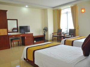 una camera d'albergo con due letti e una televisione di Hai Long Hotel Cat Ba a Cat Ba Altre 74 foto